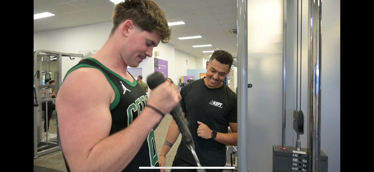 Coach Karl guiding a client through an exercise at the gym